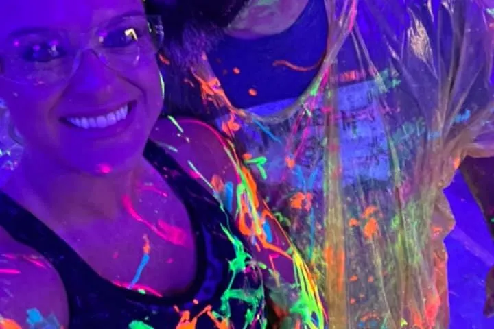 a woman wearing glasses and smiling at the camera