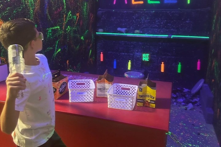 a young boy about to smash a bottle against the wall in smash alley at chaos factory