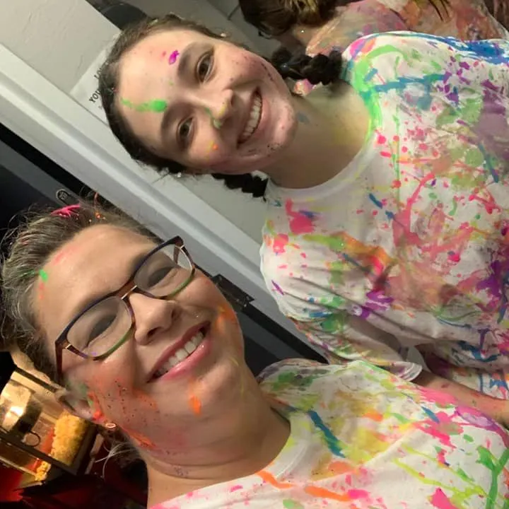 two ladies showing the aftermath of their splatter paint experience