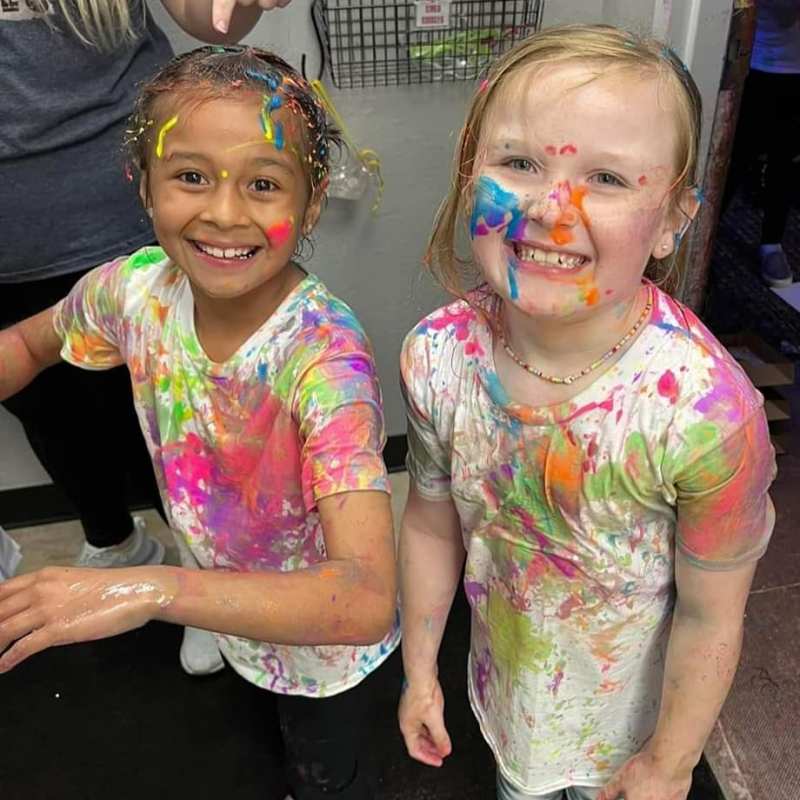 2 girls with paint all over their face and clothes