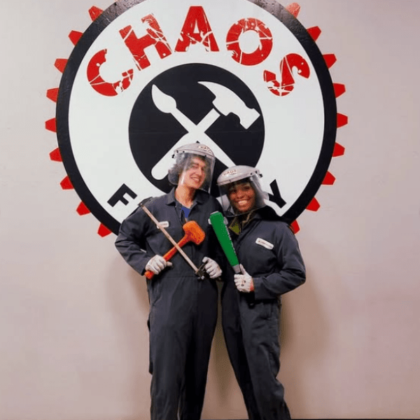 a couple posing in front of the chaos factory logo